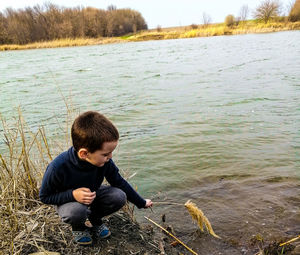 Rear view of boy enjoying in lake