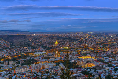 Aerial view of city against cloudy sky