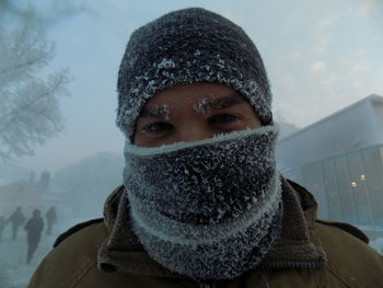 Portrait of man covered with scarf during snowfall