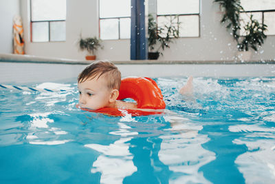 Close-up of cute boy swimming in swimming pool