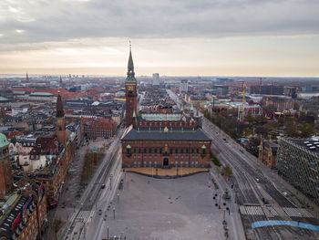 High angle view of city buildings against cloudy sky