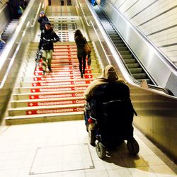 Rear view of man walking on escalator