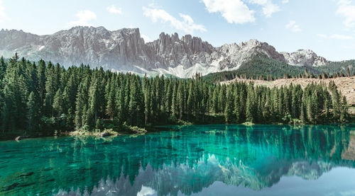 Scenic view of lake by mountains against sky