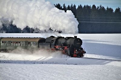 Train on railroad track against sky during winter