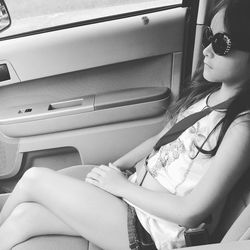 Side view of girl wearing sunglasses while sitting in car