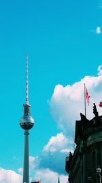 Low angle view of communications tower against cloudy sky