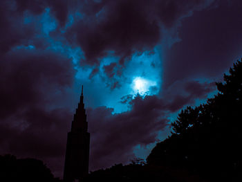 Low angle view of silhouette building against sky at night