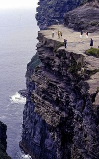 People on rock by sea