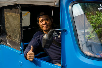 Portrait of smiling man sitting in car