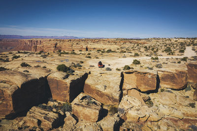 Aerial view of a car on a cliff of a utah canyon