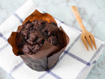 Chocolate muffin on the table with wooden fork