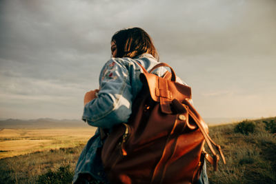 Rear view of couple on field against sky
