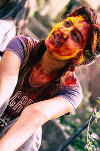 Young woman with power paint on face during holi