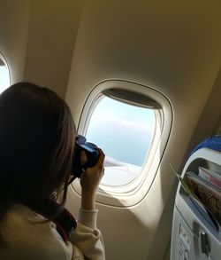 Woman photographing in airplane 