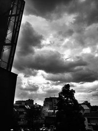 Low angle view of city against cloudy sky