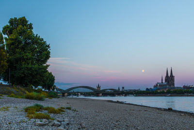 Arch bridge over sea against sky during sunset