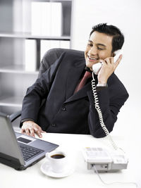 Businessman talking on phone at desk in office