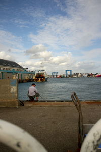 Pier in sea against cloudy sky