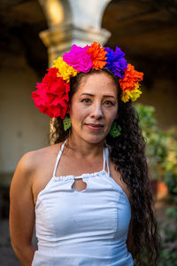 Portrait of smiling woman standing by flowering plant