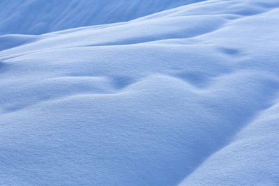 Blue and white snowdrifts background, snow texture.