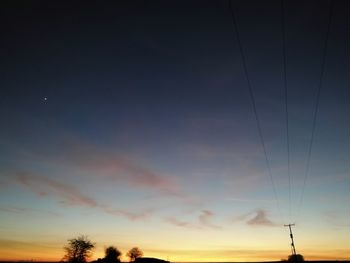 Low angle view of trees against sky during sunset