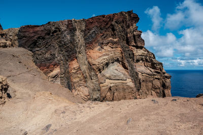 Scenic view of rock formation by sea against sky