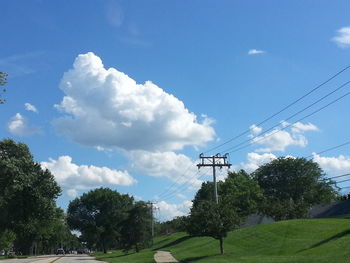 Low angle view of electricity pylon against cloudy sky