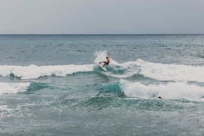 Man surfing in sea against clear sky