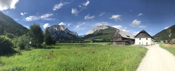 Scenic view of field and houses against sky