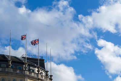 Cropped image of historic building with british flags against sky