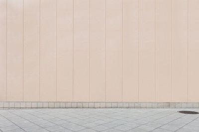 Empty footpath against wall