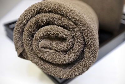 Close-up of rolled up towel in tray on white background