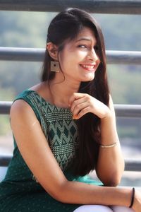 Portrait of a smiling young woman sitting outdoors