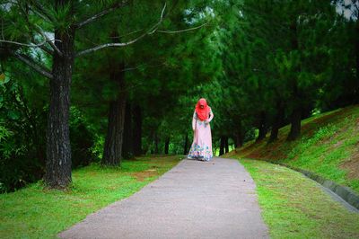 Woman walking on footpath at forest