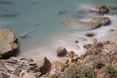 High angle view of rocks on sea shore