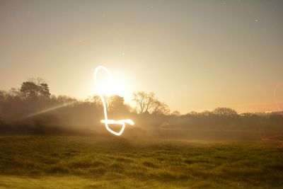 Light painting on field against sky at dawn