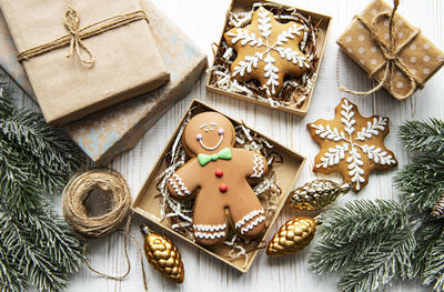 Christmas gingerbread cookies in cardboard boxes on white wooden table