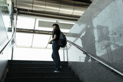 Low angle view of woman walking on staircase in building