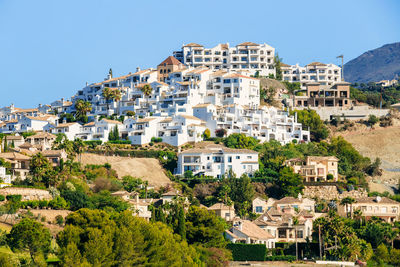 Buildings in town against clear blue sky