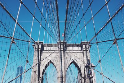 Low angle view of suspension bridge against blue sky