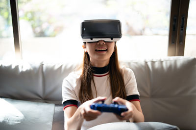 Girl playing games on virtual reality headset at home