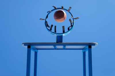 Low angle view of basketball in hoop blue sky