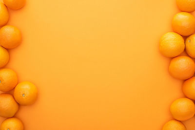 Directly above shot of oranges on yellow background
