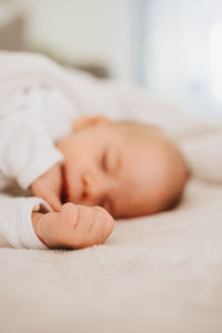 Close-up of baby sleeping on bed