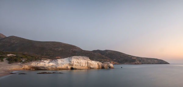 Scenic view of sea and mountains against clear sky