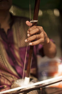 Midsection of man playing musical instrument