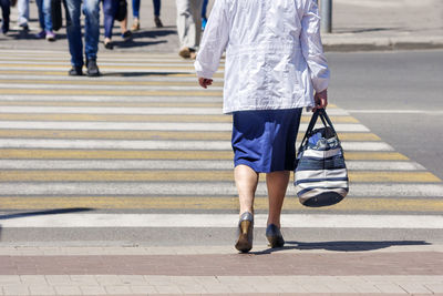 Low section of people walking on road