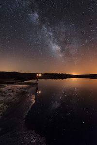 Scenic view of lake against sky at night