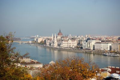 River amidst buildings in city against sky