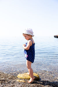 Little cute child girl playing on the seashore in summer